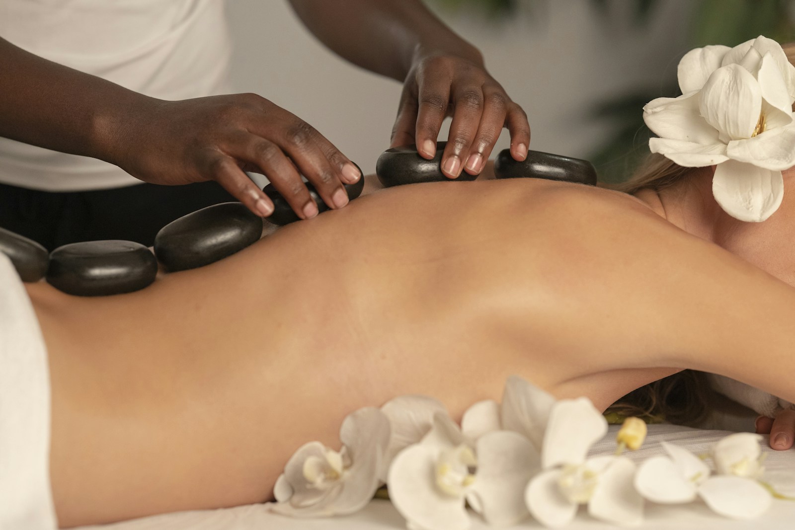 Illustrative spa scene with warm stones and white flowers